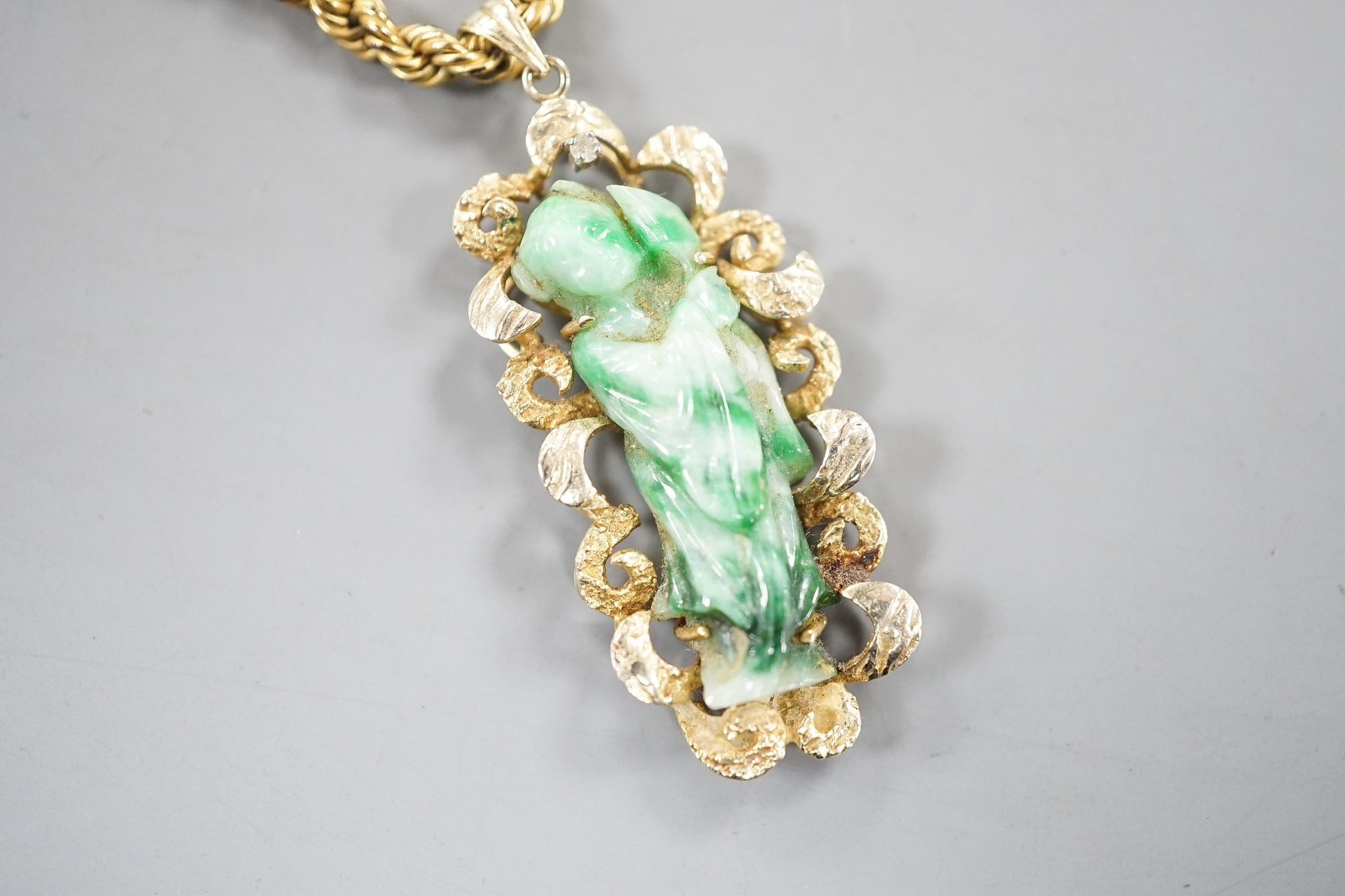 A 14k yellow metal and carved jade set pendant, 45mm, gross 8.5 grams, on a 9ct gold ropetwist chain, 56cm, 10.5 grams and an enamelled gilt white metal pendant.